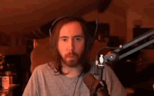 a man with long hair and a beard is wearing headphones and a microphone in front of a microphone .