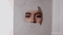 a person is painting a woman 's face with a brush on a piece of paper .