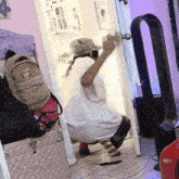 a person is kneeling down in a room holding a door
