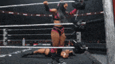 a woman in a pink outfit is standing in a wrestling ring with the word raw on the ropes