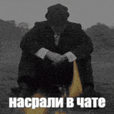 a man in a suit and hat is sitting in front of a fire with a caption in russian .