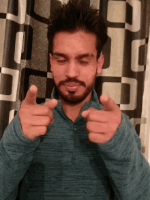 a man with a beard is laying down and giving a thumbs up