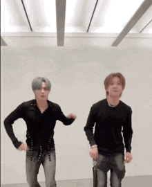 two young men are dancing together in a room .