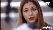 a close up of a woman 's face with red lipstick on a television screen .