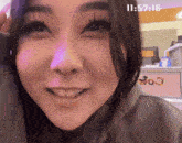 a close up of a woman 's face with a clock displaying the time of 11:57:16