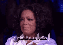 oprah winfrey is crying with her eyes closed and a foreign language written on her face .