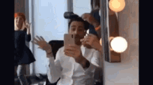a man taking a picture of himself in front of a mirror with an iphone