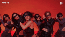 a group of women wearing sunglasses are dancing in front of a sign that says take #b