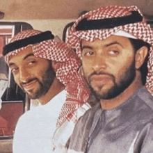 two men with beards and scarves are standing next to each other .
