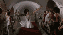 a bride in a white dress walks down the aisle