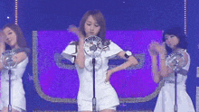 a woman stands in front of a microphone with a purple background and a sign that says " super cool "