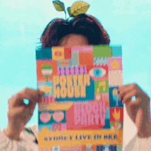 a person is holding a colorful book that says happy party on it .