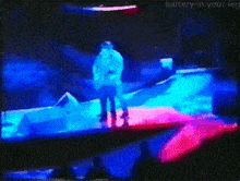 a man is playing a guitar on a stage in front of a screen that says battery-in-your-leg .