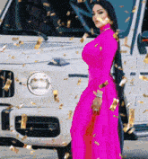 a woman in a bright pink dress is standing in front of a white car