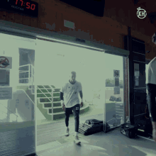 a man wearing a white shirt with the number 22 on it walks through a sliding glass door