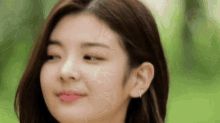 a close up of a woman 's face with her eyes closed and earrings .