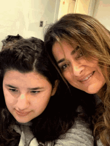 a woman and a girl are smiling for the camera