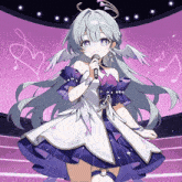 a girl with angel wings singing into a microphone on a stage