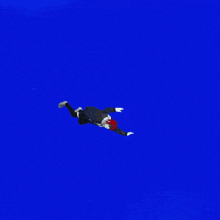 a person is flying through the air while a plane is flying in the background