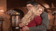 a man is hugging a woman in a red shirt