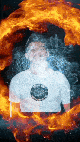 a man wearing a white shirt that says afff on it is surrounded by fire