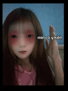 a girl with red eyes and black eyes is giving a high five in a foreign language .