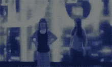 a blurry picture of two people standing next to each other in front of a building .