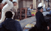 a man in a hard hat stands in front of a conveyor belt holding a sign that says ' safety ' on it