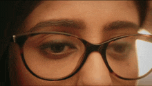 a close up of a woman wearing glasses looking at something