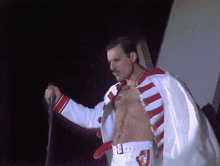 a man without a shirt is holding a microphone in his hand