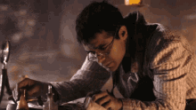 a man wearing glasses is working on a piece of paper