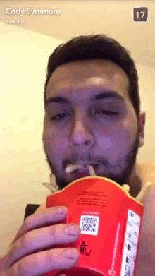 a man eating a box of mcdonald 's french fries with the number 17 in the corner