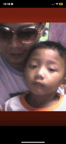 a phone screen shows a picture of a man and a child and the time is 12:18