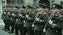 a group of soldiers are standing in a line with their arms crossed