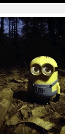 a yellow minion with big eyes is standing on a pile of leaves
