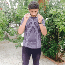 a man wearing a purple shirt with a geometric design on it