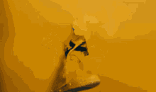 a person in a yellow hoodie is standing in front of a yellow wall