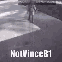 a person is walking down a sidewalk with the words `` notvinceb1 '' on the bottom .