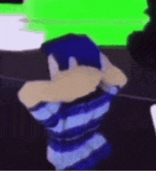 a person in a blue striped shirt is covering their face with their hands in front of a green screen .