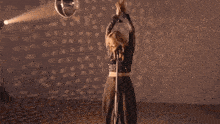 a woman is singing into a microphone while holding a knife in her hand .