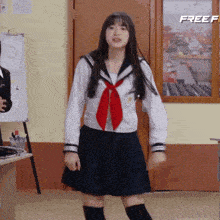 a girl in a sailor uniform is dancing in front of a door that says freef