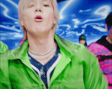 a close up of a person wearing a green jacket and a silver necklace