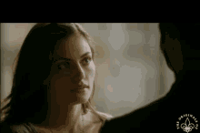 a woman looking at a man with the words the originals written on the bottom