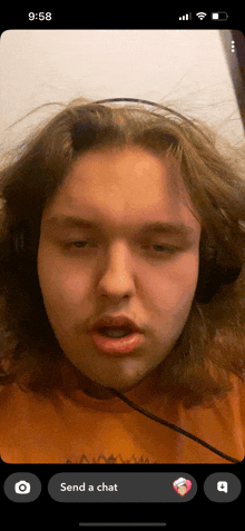 a phone screen shows a man wearing headphones and the words send a chat