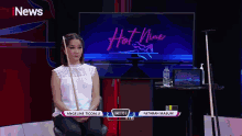 a woman holding a pool cue sitting in front of a tv screen that says inews