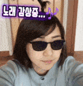 a woman wearing sunglasses has a bun in her hair and a sticker that says ' n ' on it