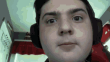 a close up of a man wearing headphones making a face