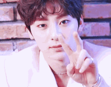 a young man is making a peace sign with his fingers