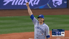 a baseball player wearing a toronto jersey holds his fist up in the air