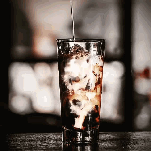 Iced coffee cocktail or frappe with ice cubes and cream in different  glasses with jezva, silver shaker, bottle of rum, coffee beans around on  white ma Stock Photo - Alamy